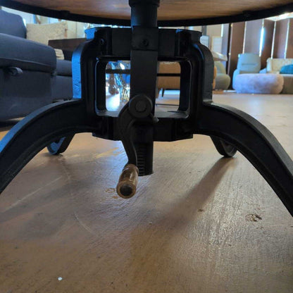 Close-up of a wooden table base with metal legs in an indoor setting.