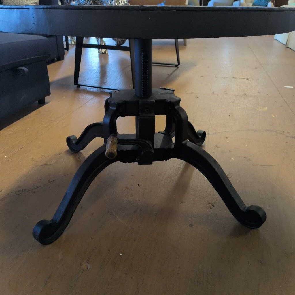 Black metal table base on a wooden floor
