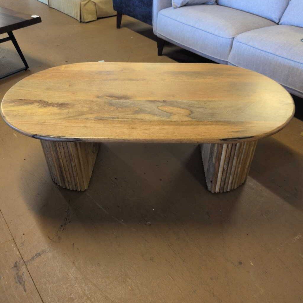 Wooden coffee table in a room with a sofa and other furniture.