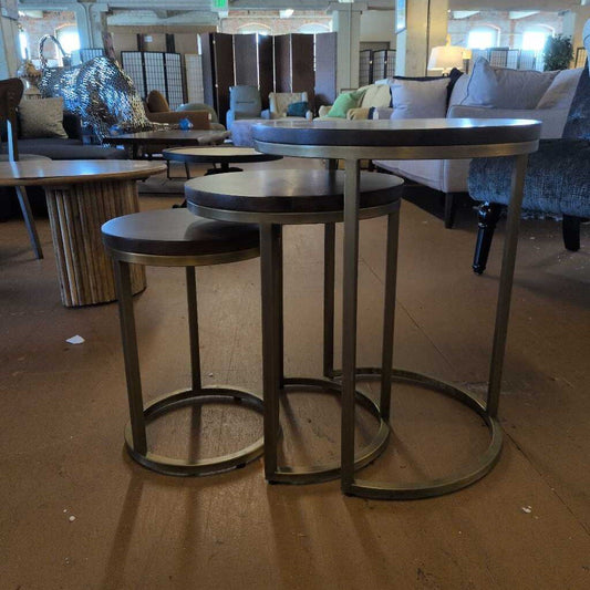 Set of round metal tables with stools in a showroom setting