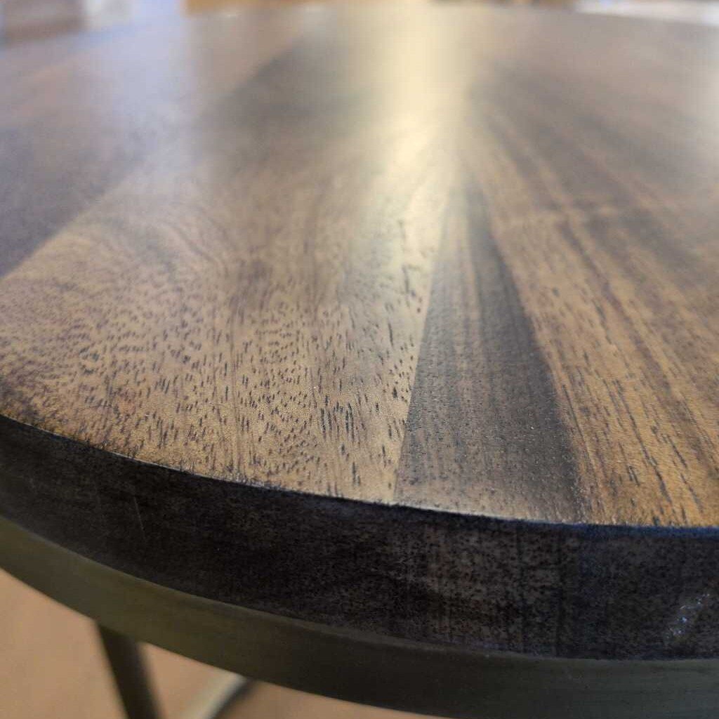Close-up of a wooden table surface with visible grain and texture.