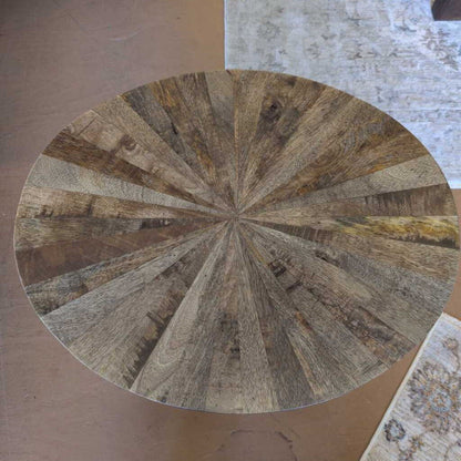 Round wooden table top with a radial pattern on a neutral background