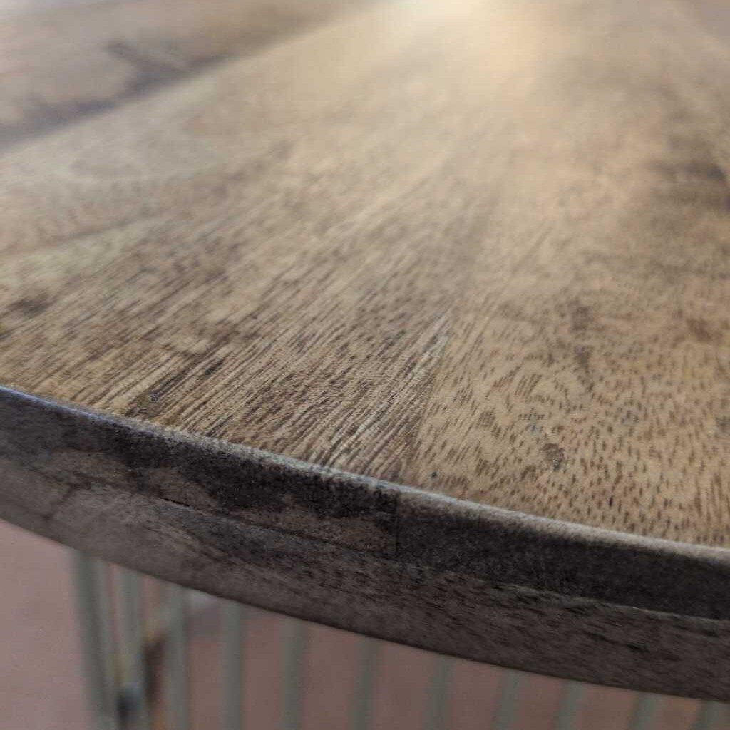 Close-up of a wooden table surface with visible grain and texture.