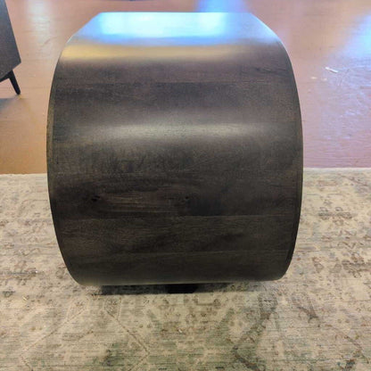 Large roll of black metal sheet on a textured surface
