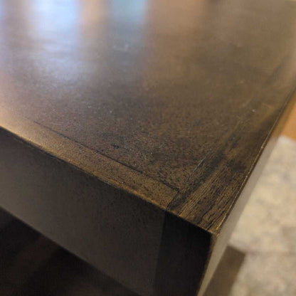 Close-up of a dark wooden surface with visible grain and texture.