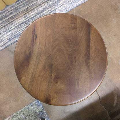 Round wooden stool on a tiled floor