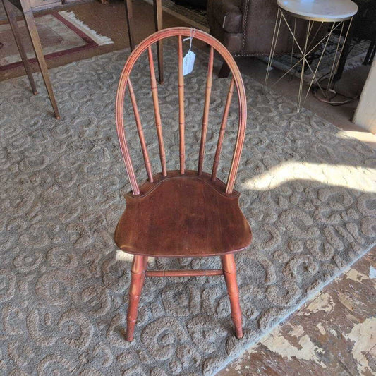 Wooden chair with a tag on a textured carpet