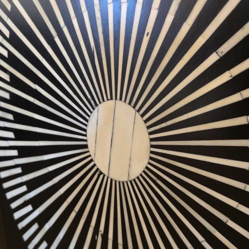 Black and white circular pattern resembling a sunburst design.