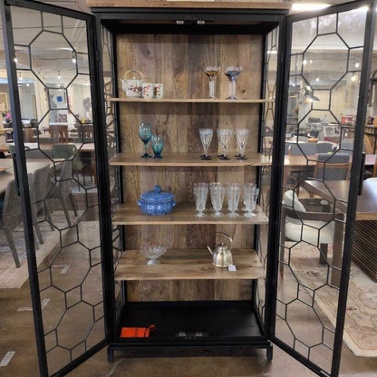 Wooden cabinet with glass doors displaying various items in a room setting.