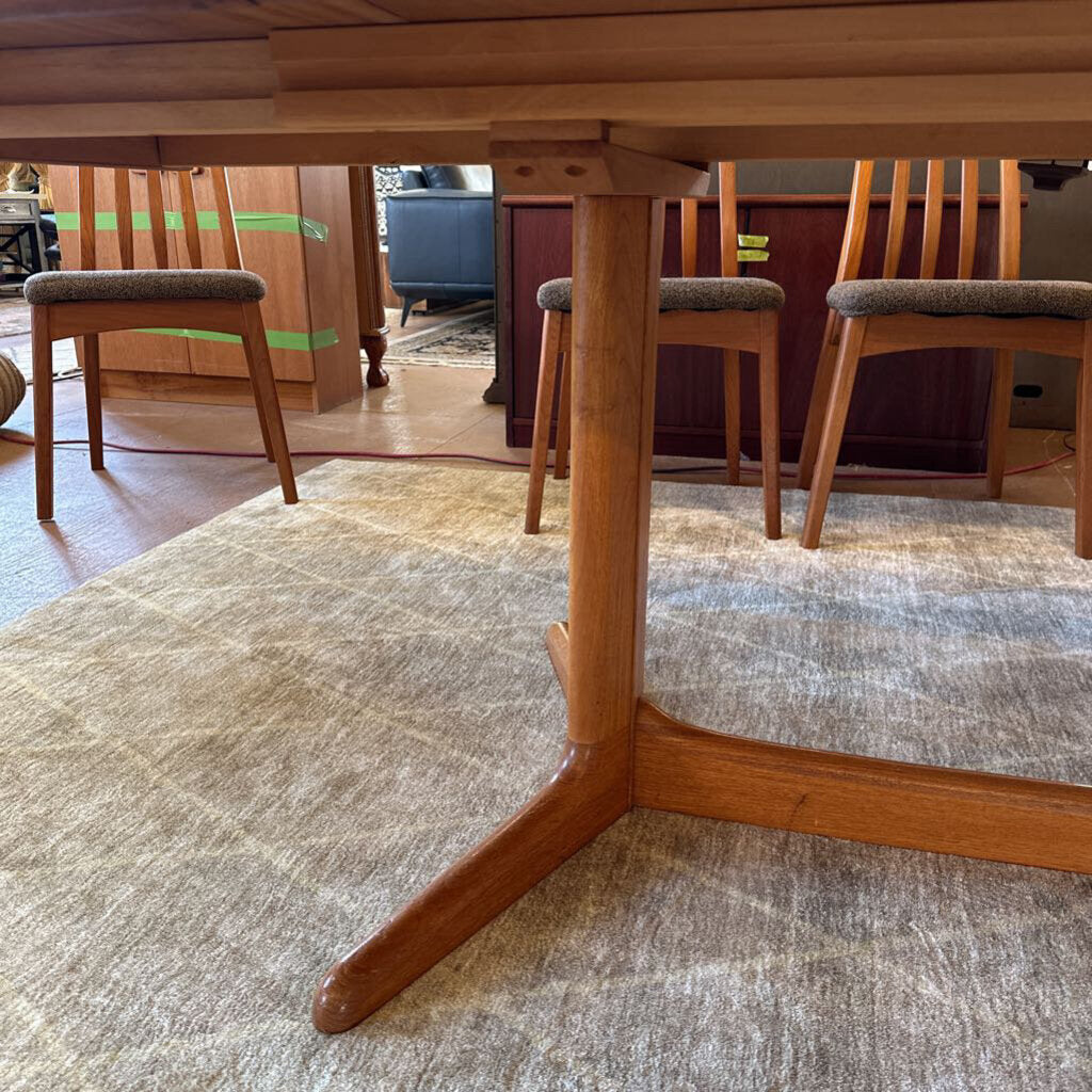 Wooden dining table with chairs on a textured floor