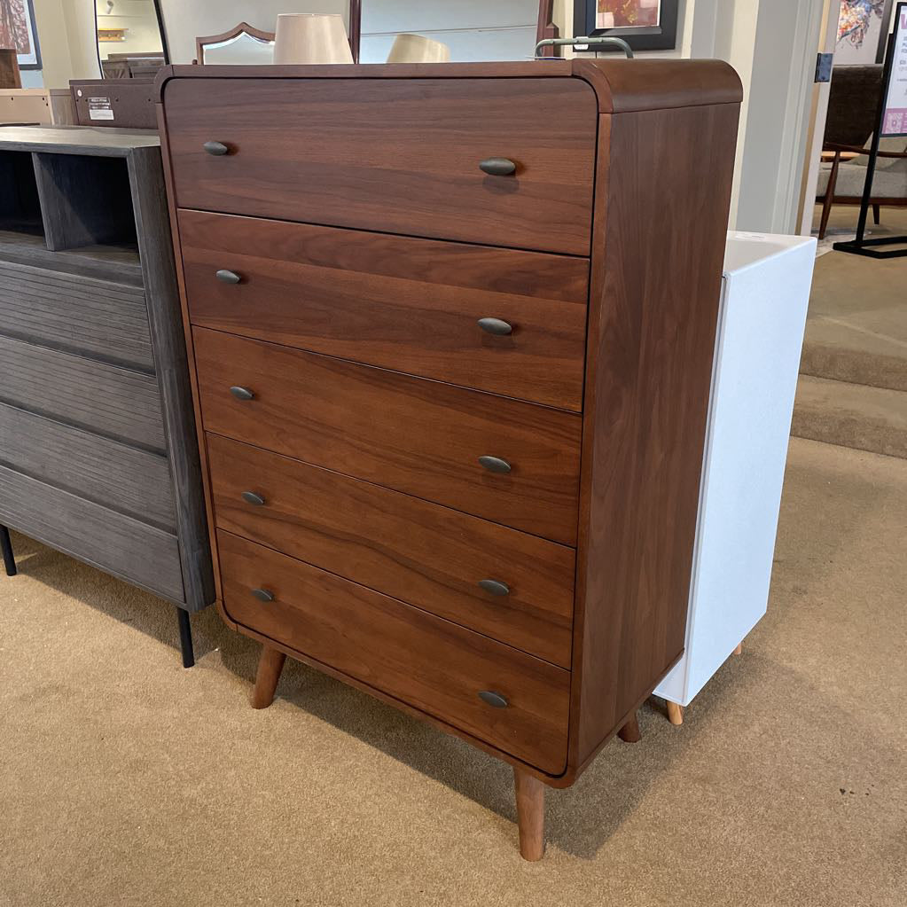Wooden dresser with multiple drawers in a showroom setting