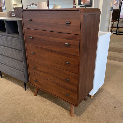 Wooden dresser with multiple drawers in a showroom setting