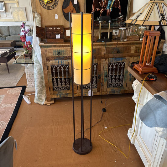 Floor lamp with a warm light in a cluttered room