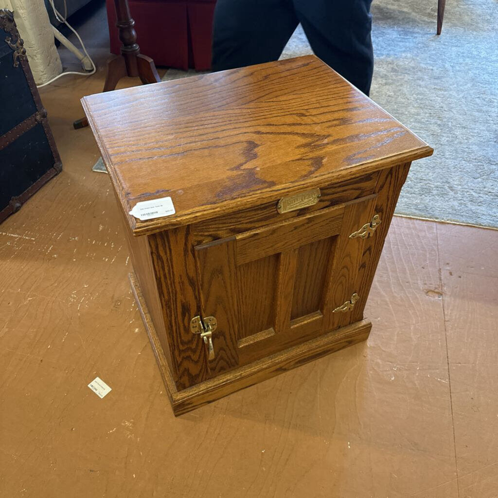 Wooden cabinet with brass handles on a wooden floor