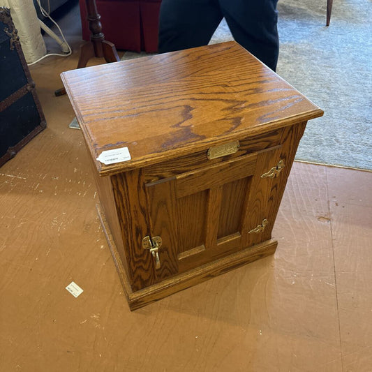 Wooden cabinet with brass handles on a wooden floor
