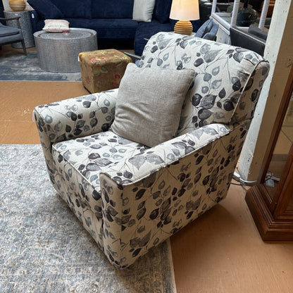Floral-patterned armchair with a gray pillow in a room setting.