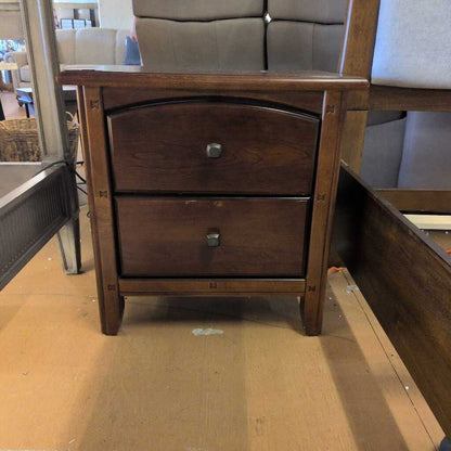 Wooden nightstand with two drawers on a cardboard floor