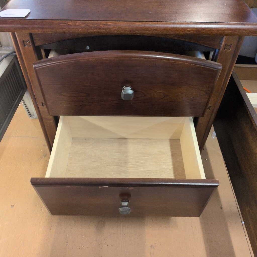 Wooden drawer with a metal handle on a wooden surface