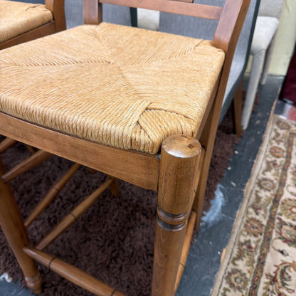 Wooden chair with a woven seat on a carpeted floor