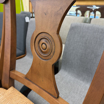Close-up of a wooden chair with intricate carvings in an indoor setting.