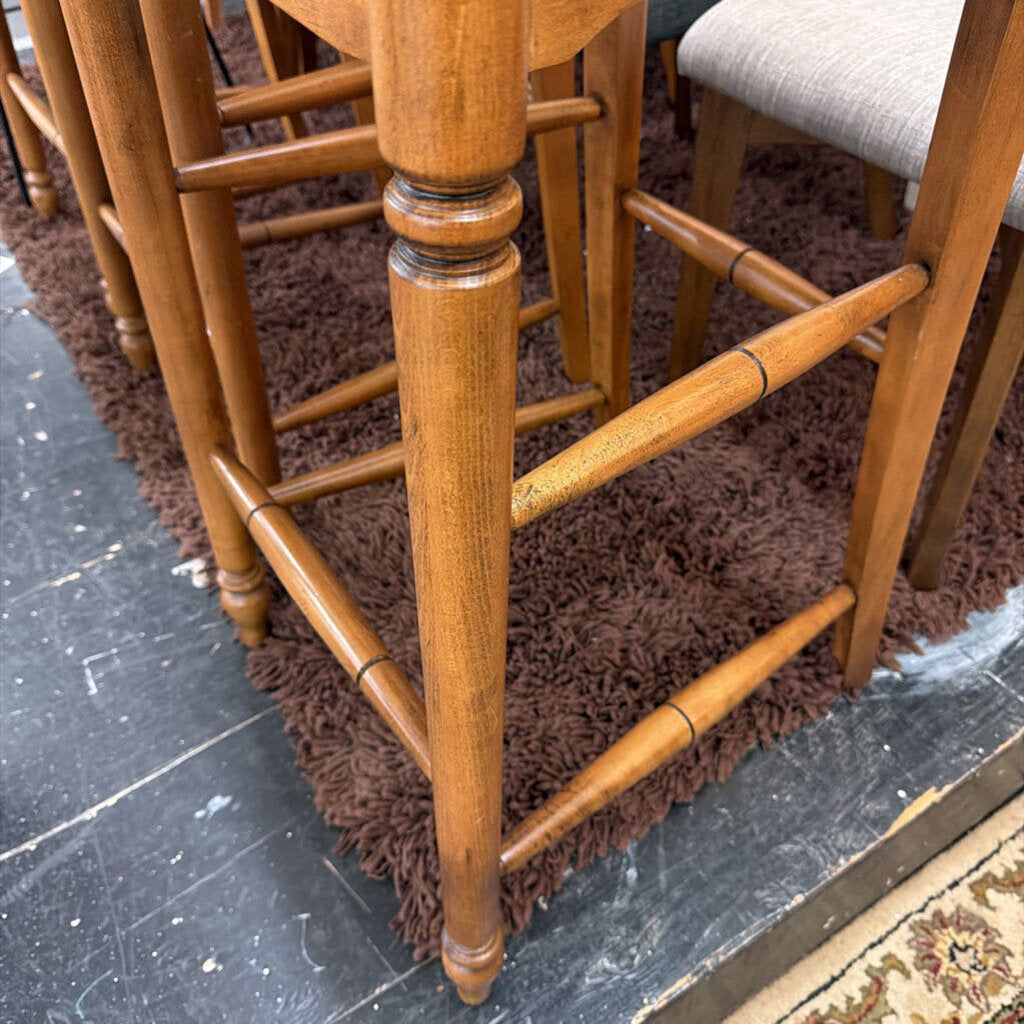 Wooden bar stools on a dark floor with a brown rug.