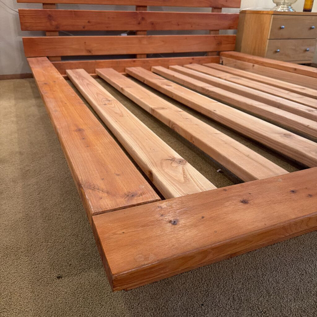 Wooden bed frame on a carpeted floor