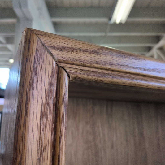Close-up of a wooden frame corner with a blurred indoor background