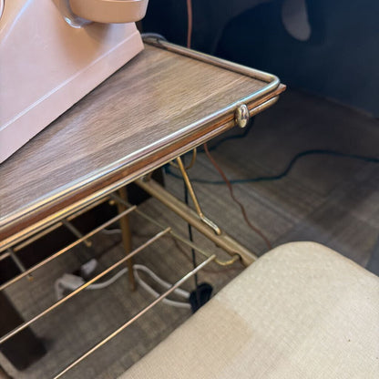 Wooden shelf with pink object and gold hangers in a room setting
