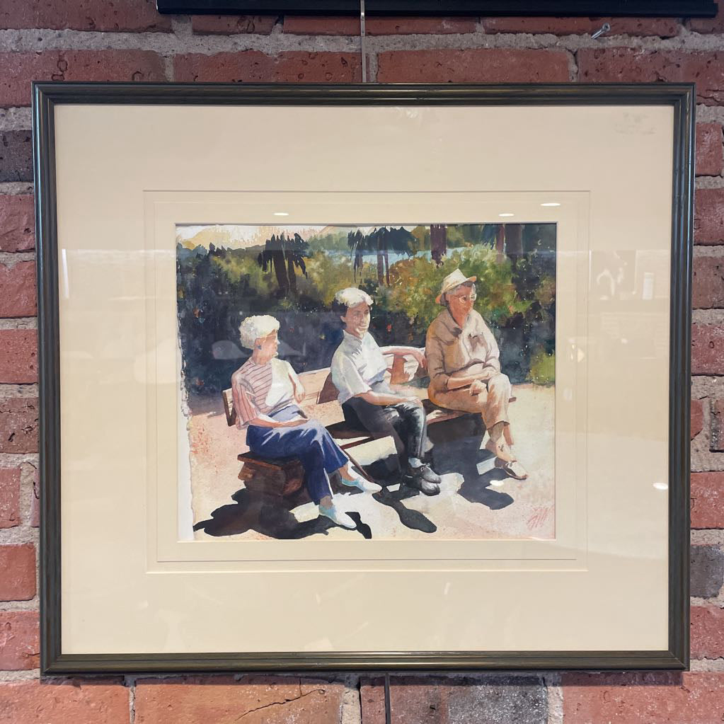 Framed painting of three people sitting on a bench against a brick wall.