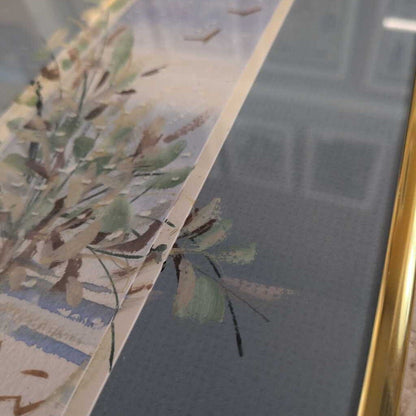 Close-up of a floral painting with a gold frame on a textured wall.