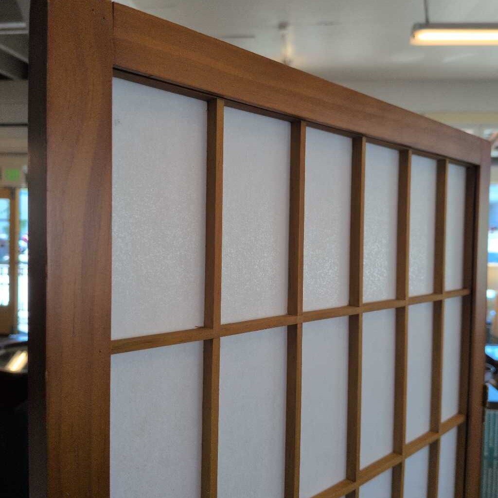 Wooden room divider with white panels in a store setting