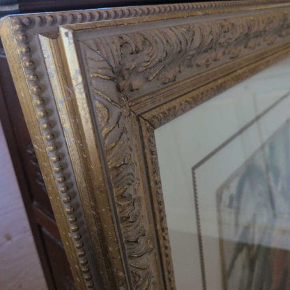 Close-up of an ornate gold mirror frame with intricate detailing.