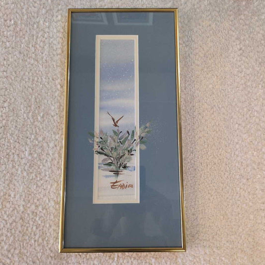 Framed artwork of a plant on a textured wall