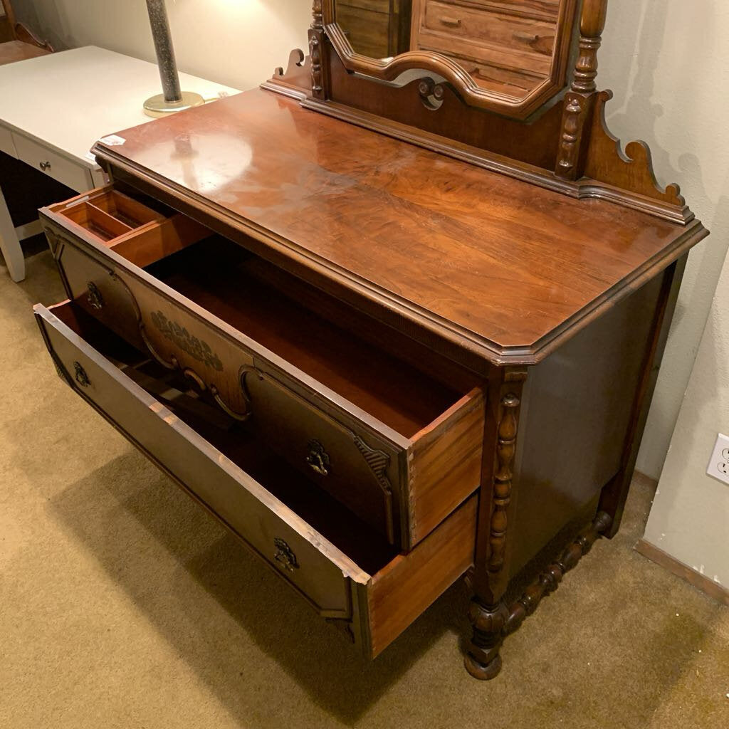 Wooden dresser with open drawer in a room setting