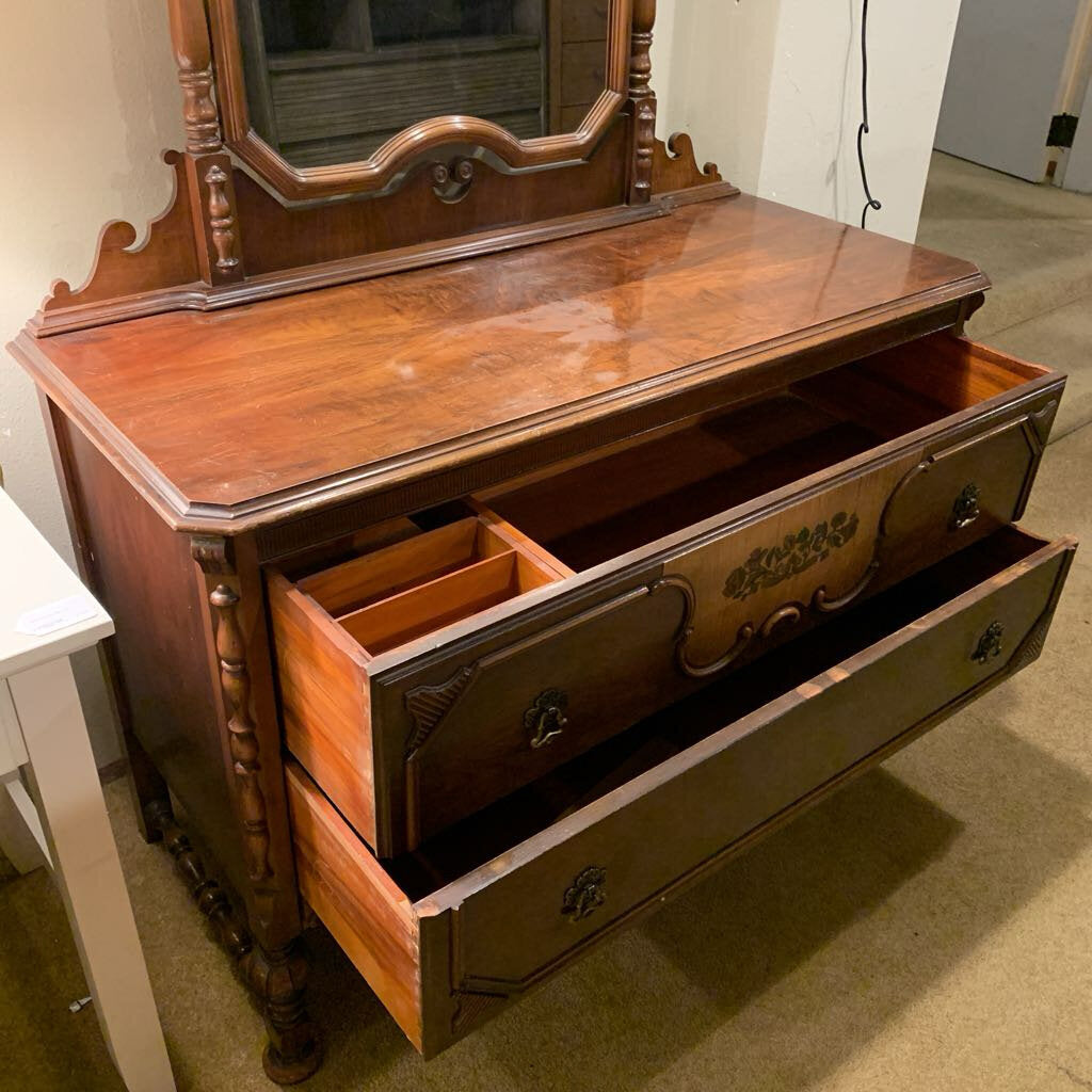 Wooden dresser with mirror on top in a room setting