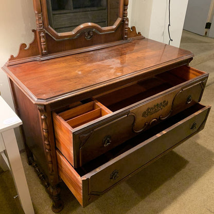 Wooden dresser with mirror on top in a room setting