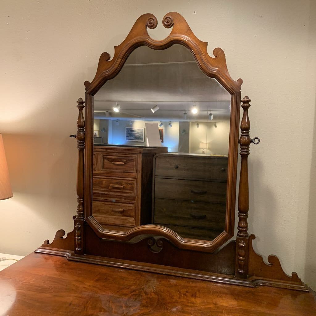 Wooden mirror with decorative frame on a wooden surface