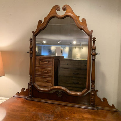 Wooden mirror with decorative frame on a wooden surface