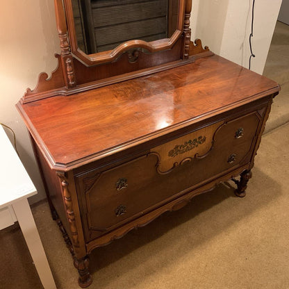Wooden dresser with mirror on top in a room setting
