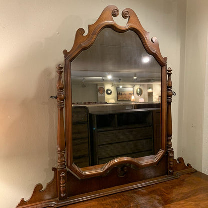 Wooden mirror with decorative frame on a wooden surface