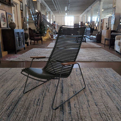 Modern black chair in a furniture store with various items in the background