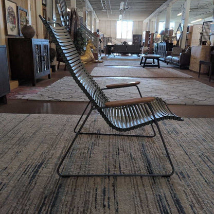 Modern lounge chair on a patterned rug in a showroom setting