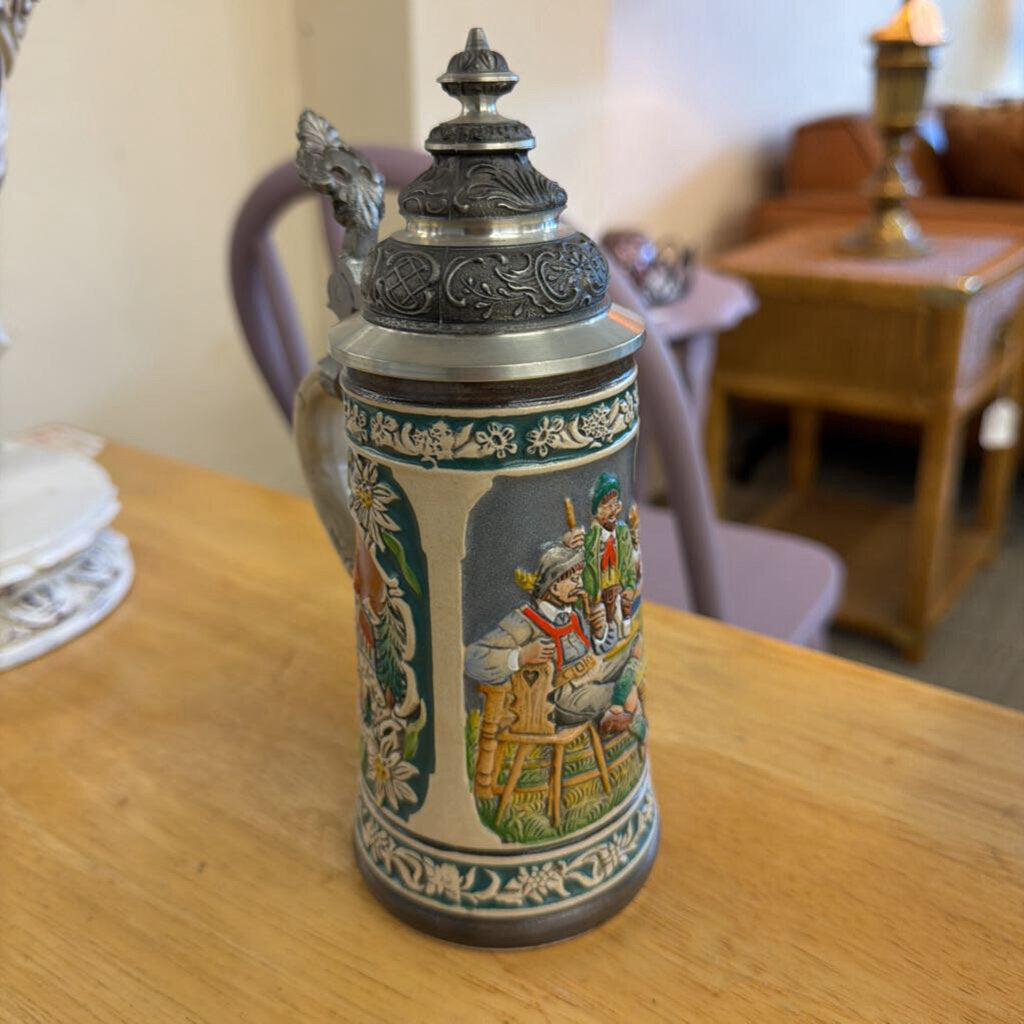 Decorative ceramic stein with detailed artwork on a wooden table