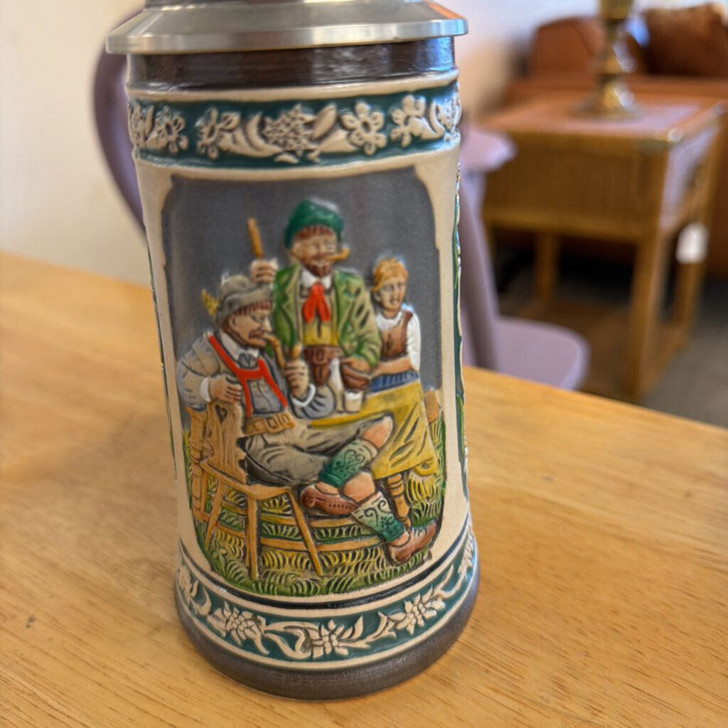 Decorative ceramic stein with painted scene on a wooden table