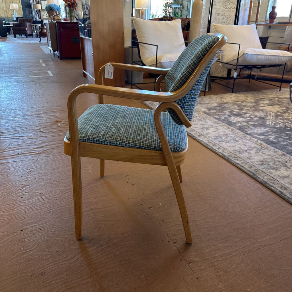 Chair with blue patterned cushion on a wooden floor in a room with other furniture.