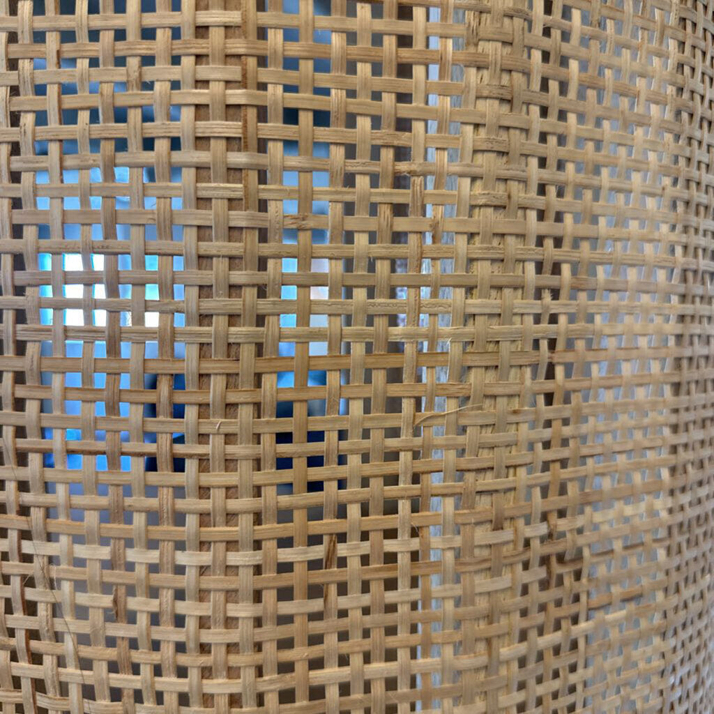 Close-up of woven rattan material with a blue background