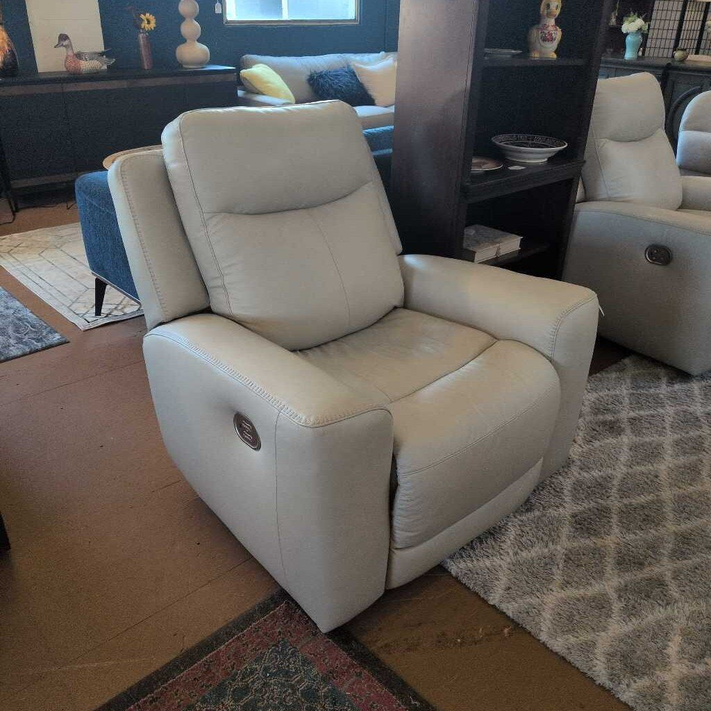 White recliner chair in a living room setting with a rug and furniture.