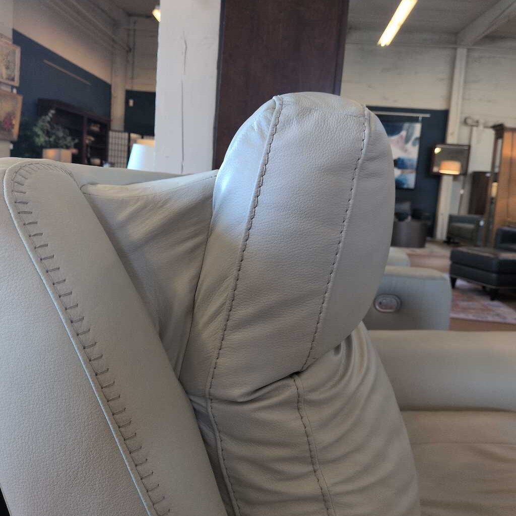 Close-up of a gray sofa with visible stitching in an indoor setting.
