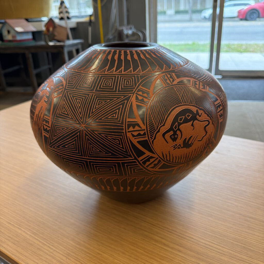 Decorative brown vase with geometric patterns on a wooden table