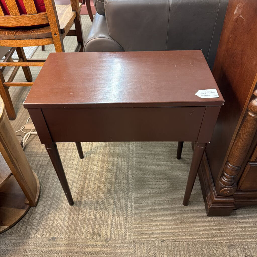 Wooden side table in a room with furniture and carpet
